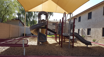 A playground with a yellow canopy and a slide at Foothills Court, Phoenix AZ